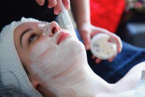 beautician performs facial treatment