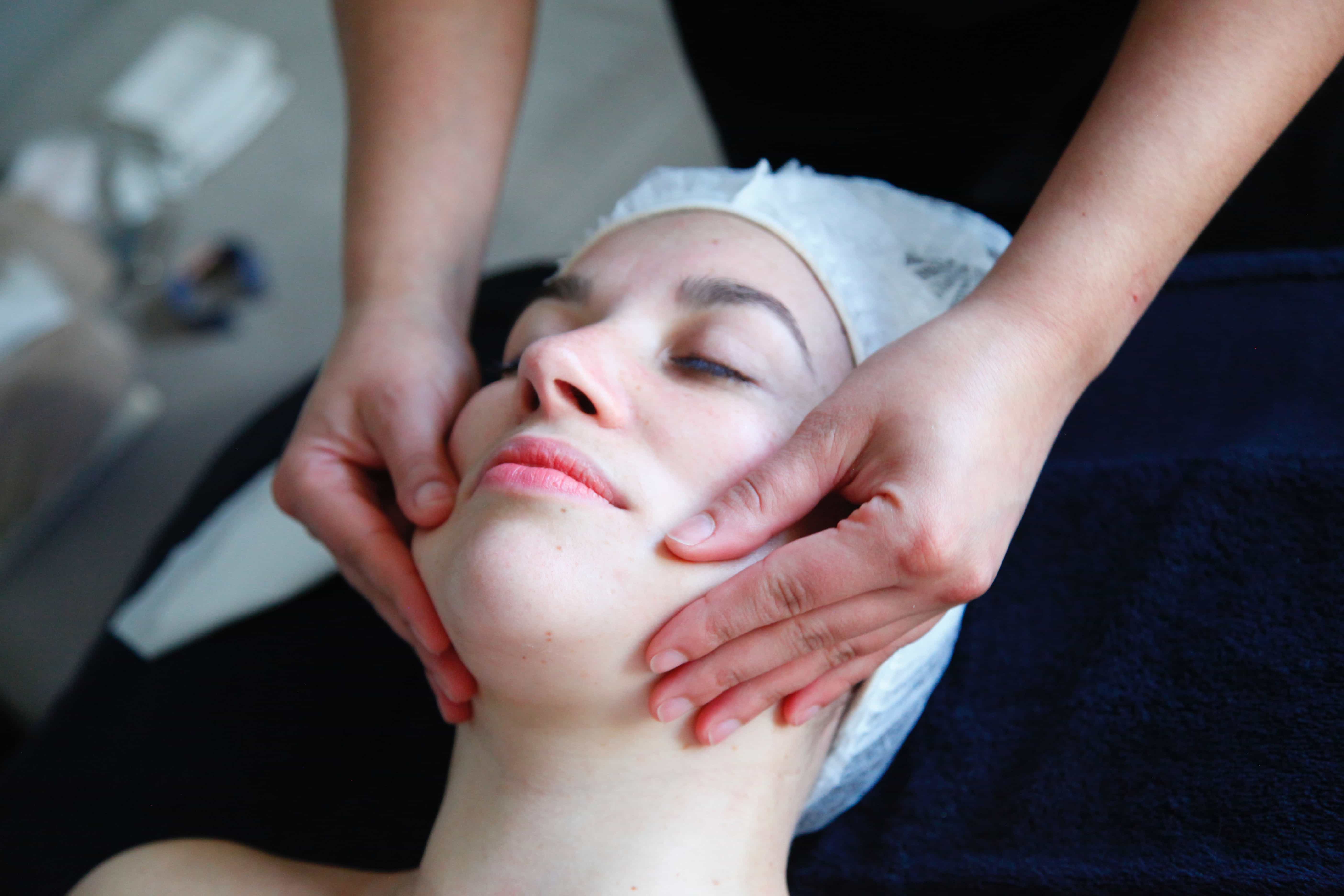 beautician performs a facial treatment on vacation