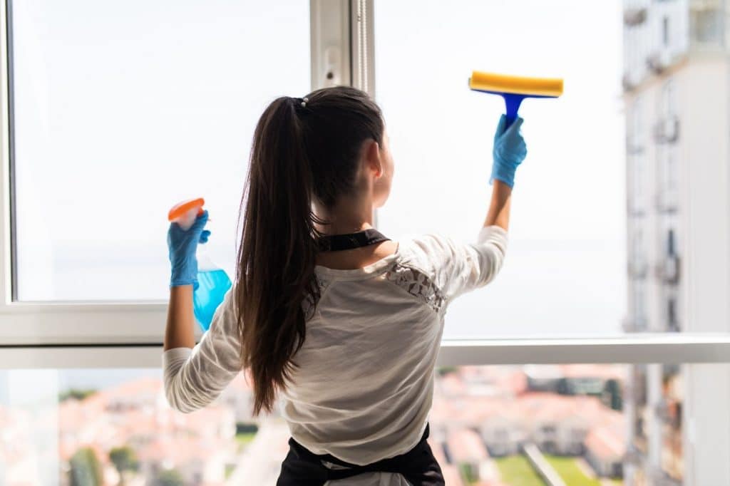 Cleaning lady cleaning the windows with window cleaning equipment