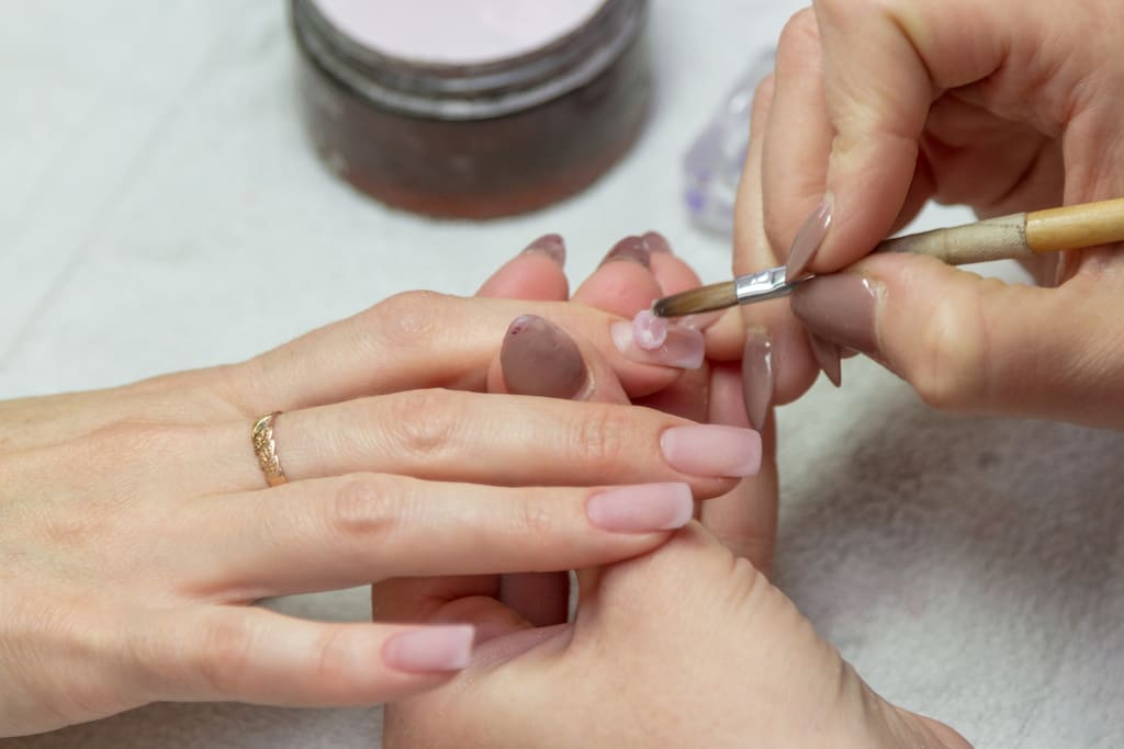 woman applying gel to nail