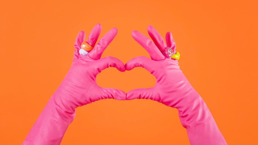 Femme de ménage faisant un coeur avec ses gants de ménage 
