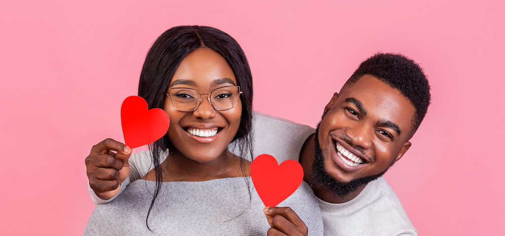 Portrait of black couple in love, with heart shaped cards