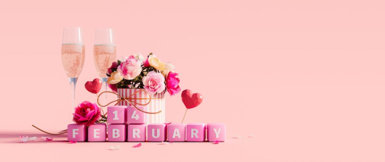 Valentine's day decoration and two champagne glasses on pink background