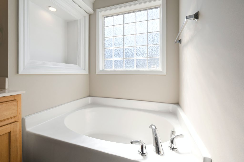 white-ceramic-bathtub-near-window- how to unblock a shower drain with standing water