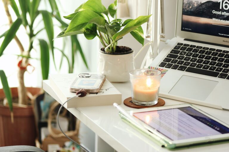 work-space-with-candle-and-charging-phone-on-desk