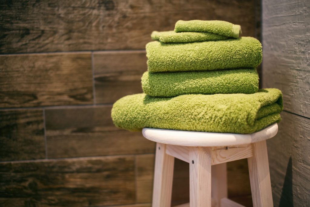 stack of clean towels on a white stool-how often should you wash your towels