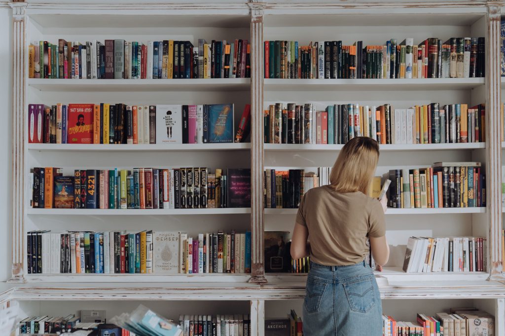 Blonde woman organising books- how to declutter sentimental items