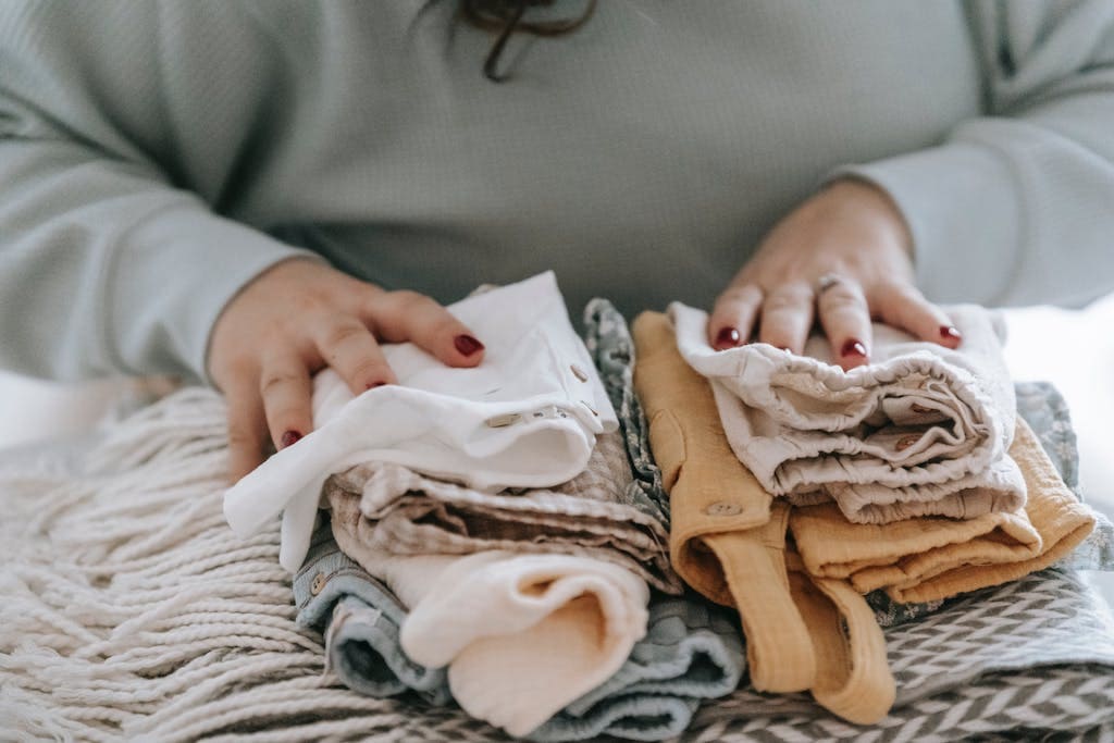woman folding baby clothes
