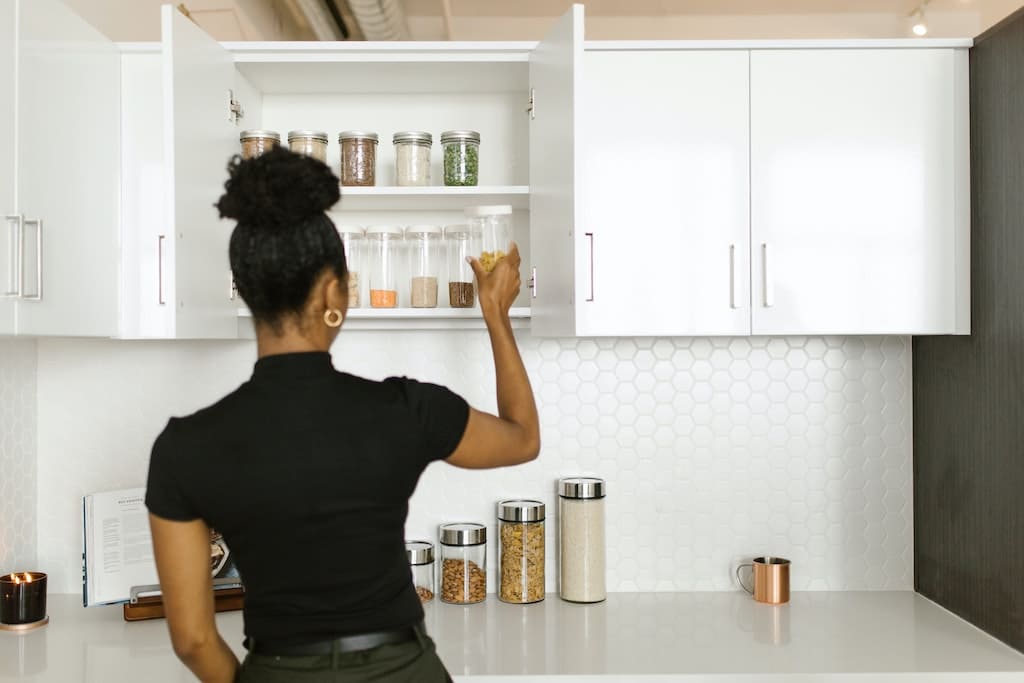 woman organising containers in kitchen