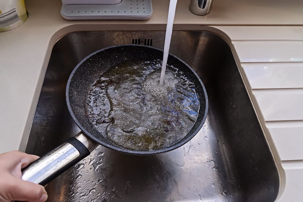 Man cleaning burnt pan