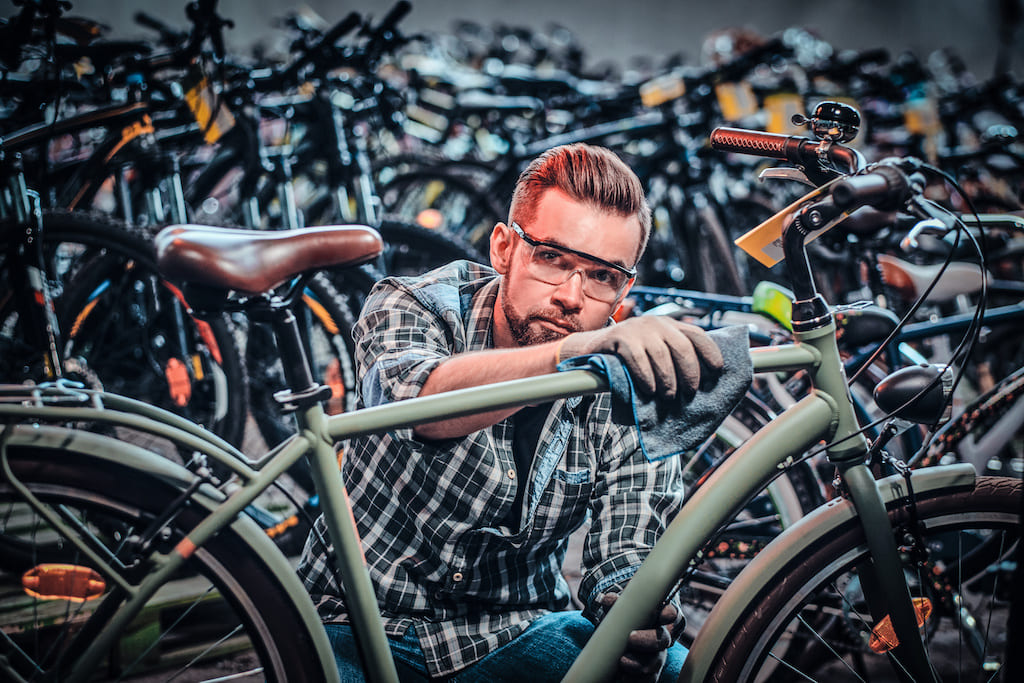 Man cleaning bicycle with cloth