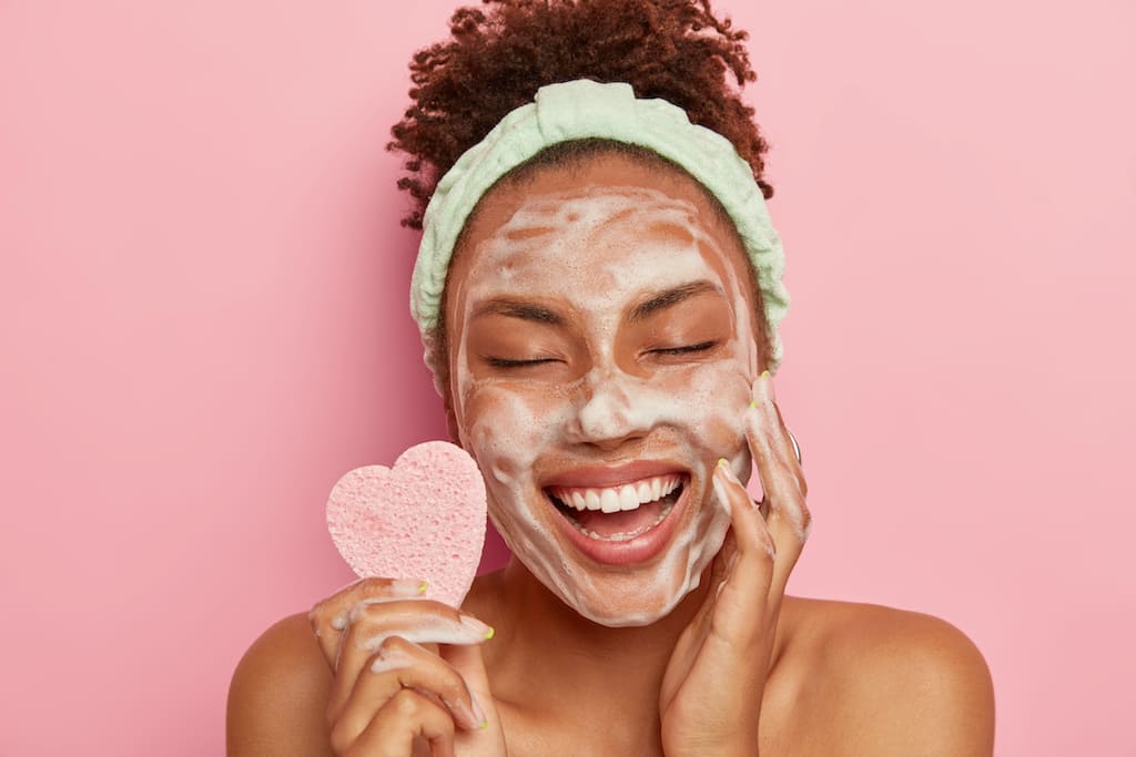 Woman with facial cleanser for morning skincare routine